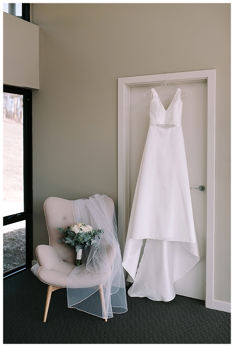 wedding dress hanging from doorframe