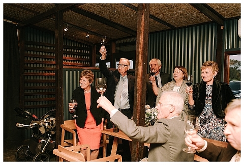 guests holding glasses up at wedding