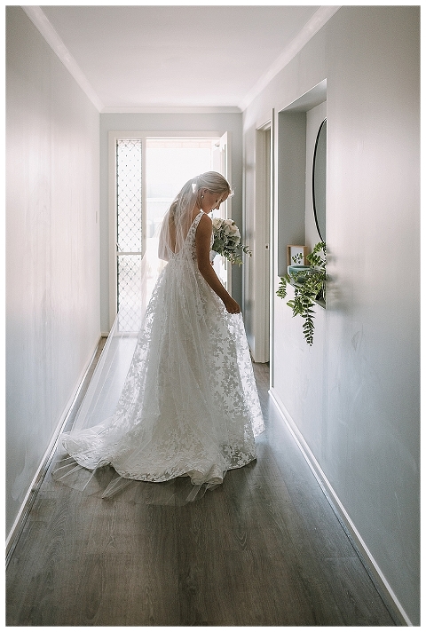 Bride admiring her dress in hallway