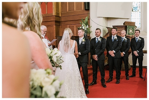 Groom smiling at bride during church ceremony