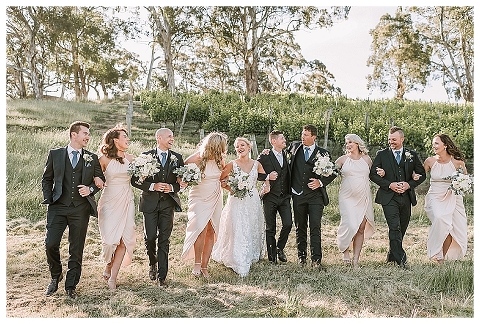 bridal party linking arms walking downhill at golding wines